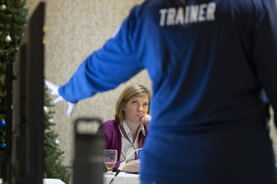 In this Monday, Dec. 16, 2019, photo, Karen Brenson Bell, from North Carolina, listens during an exercise run by military and national security officials, for state and local election officials to simulate different scenarios for the 2020 elections, in Springfield, Va. These government officials are on the front lines of a different kind of high-stakes battlefield, one in which they are helping to defend American democracy by ensuring free and fair elections. (AP Photo/Alex Brandon)