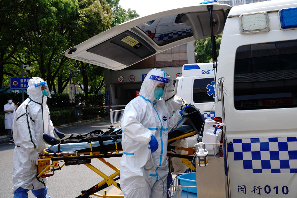 In this photo released by China's Xinhua News Agency, medical personnel transfer a patient from an ambulance at the Minhang Hospital affiliated to Fudan University in Shanghai, Wednesday, April 20, 2022. In mainland China, the death toll rose to more than 20 in an outbreak in Shanghai that has all but shut down the country's largest city. (Zhang Jiansong/Xinhua via AP)