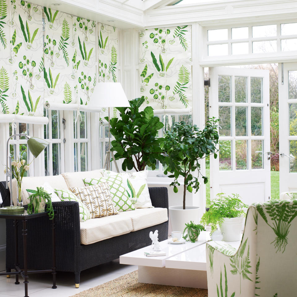 White conservatory with botanical printed armchair, cushions and blines