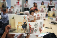 In this Aug. 8, 2019 photo, protesters with papers of "No Abe!" signs and a photo of a statue of a girl symbolizing the issue of wartime "comfort women" chant a slogan during their gathering in Tokyo. South Korea and Japan have locked themselves in a highly-public dispute over history and trade that in a span of weeks saw their relations sink to a low unseen in decades. (AP Photo/Eugene Hoshiko)