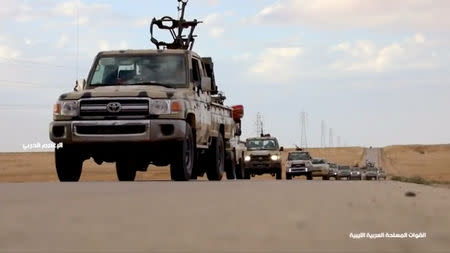 Pickup trucks with mounted weapons drive on a road in Libya, April 4, 2019, in this still image taken from video. Reuters TV via REUTERS
