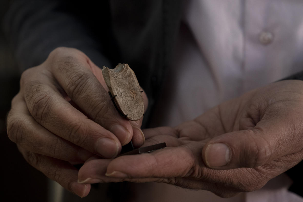 Jihad Yassin, director general of excavations and museums in the Palestinian Tourism and Antiquities Ministry, holds a 2,700-year-old ivory incense spoon plundered from a site in the occupied West Bank, seized in late 2021 by the Manhattan District Attorney's office as part of a plea deal with billionaire hedge fund manager Michael Steinhardt, at his office in the West Bank city of Bethlehem, Thursday, Jan. 19, 2023. Earlier this month, American officials handed over the artifact to the Palestinians in what the U.S. State Department's Office of Palestinian Affairs said was "the first event event of such repatriation" by the U.S. to the Palestinians. (AP Photo/ Maya Alleruzzo)