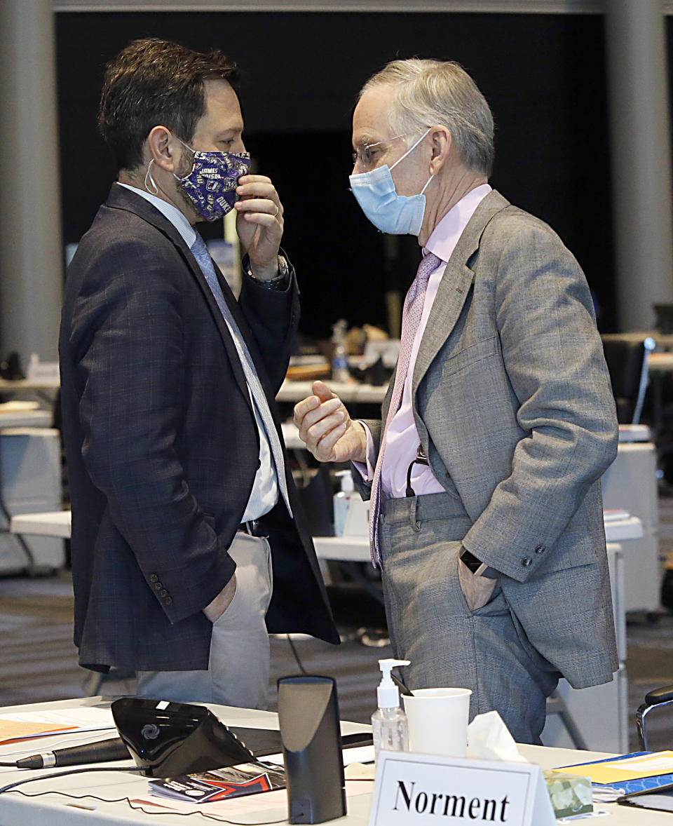 Sen. Scott Surovell, D-Fairfax, left, confers with Senate Minority Leader Tommy Norment, R-James City, right, during the floor session of the Virginia Senate inside the Science Museum in Richmond, Va., Friday, Jan. 29, 2021. Surovell asked the Senate members to move SB1165, his legislation eliminating the death penalty, to Monday. (Bob Brown/Richmond Times-Dispatch via AP)