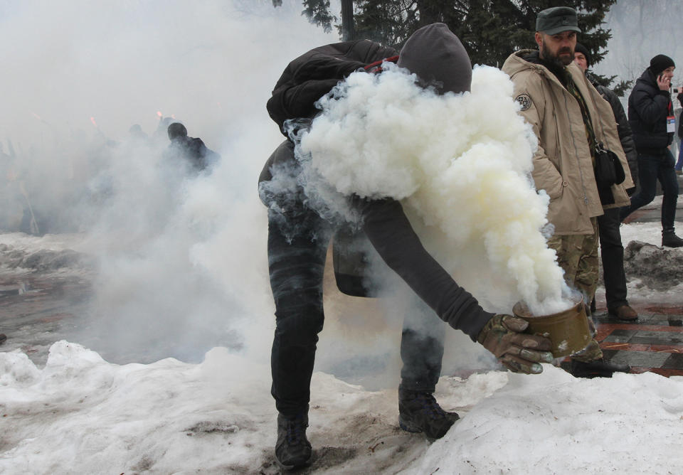 <p>A member of a nationalist group carries a smoke during a rally at a parliament to mark the third anniversary of the Maidan protests on the “March of National Dignity” downtown Kiev, Ukraine February 22, 2017. (Sergii Kharchenko/NurPhoto via Getty Images) </p>