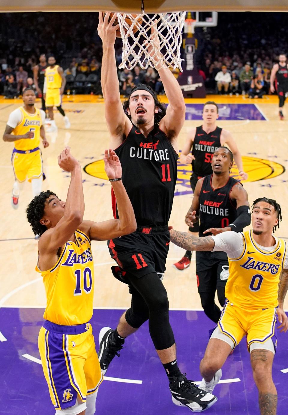 The Heat's Jaime Jaquez Jr. splits the defense of the Lakers' Max Christie (left) and Jalen Hood-Schifino to score a basket during Miami's 110-96 win in Los Angeles on Wednesday night. The Camarillo High graduate scored 16 points and also dished out eight assists.