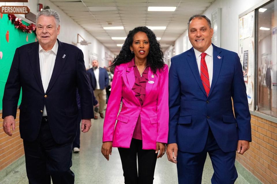 Mazi Pilip, centre, arrives to vote early at a polling station in Massapequa, New York, on Friday with former GOP congressman Peter King and Oyster Bay town supervisor Joseph Saladino (AP)