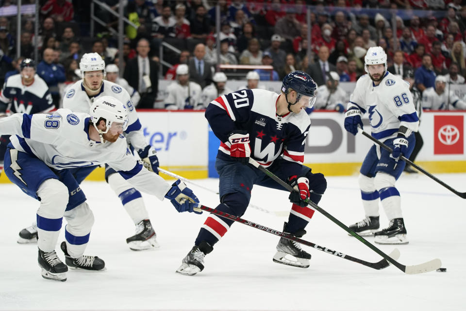 Washington Capitals center Lars Eller, center, skates past Tampa Bay Lightning defenseman Nick Perbix, left, defenseman Mikhail Sergachev (98) and right wing Nikita Kucherov (86) in the first period of an NHL hockey game, Friday, Nov. 11, 2022, in Washington. (AP Photo/Patrick Semansky)