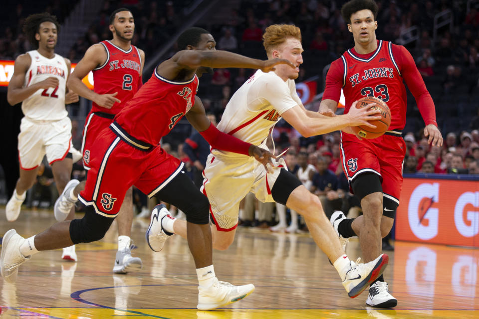 Arizona guard Nico Mannion (1) drives to the basket between St. John's guard Greg Williams Jr. (4) and forward Ian Steere (33) during the second half of an NCAA college basketball game Saturday, Dec. 21, 2019, in San Francisco. (AP Photo/D. Ross Cameron)