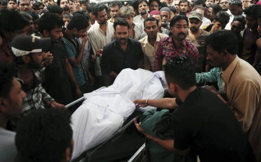 Pakistani relatives carry the body of a garment factory fire victim during a funeral in Karachi