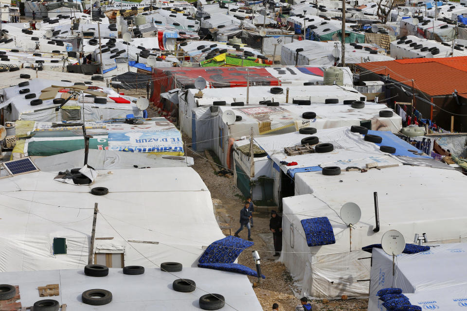 Syrian refugee stand outside their tents after heavy rain at a refugee camp, in the town of Bar Elias, in the Bekaa Valley, Lebanon, Thursday, Jan. 10, 2019. A storm that battered Lebanon for five days displaced many Syrian refugees after their tents got flooded with water or destroyed by snow. (AP Photo/Bilal Hussein)