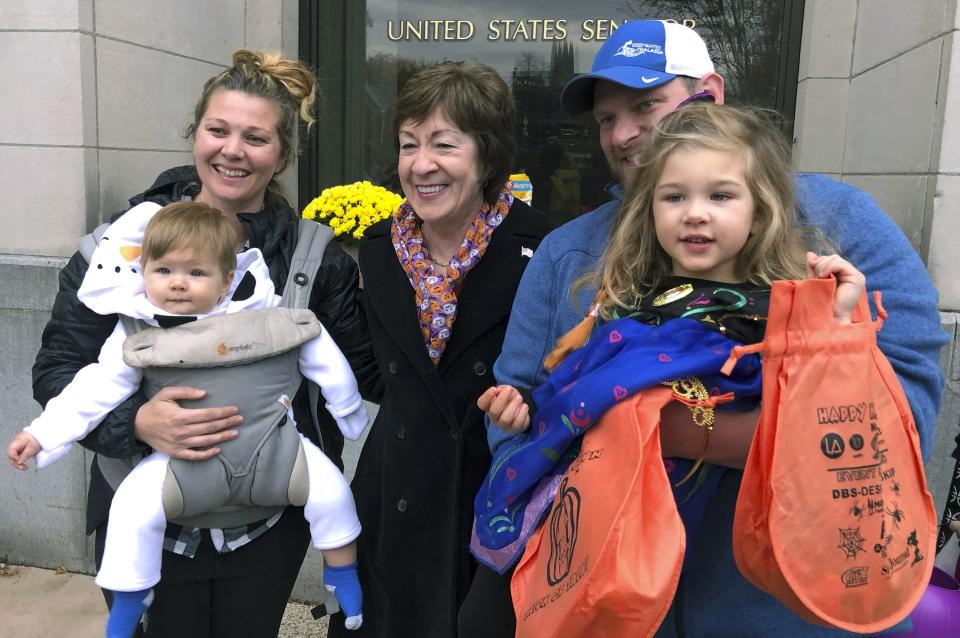 In this Friday, Oct. 25, 2019 photo, Sen. Susan Collins, R-Maine, poses with citizens for a photo outside her office during a tricks-or-treat event hosted by the local chamber of commerce in Lewiston, Maine. Collins is expected to make a formal announcement on her reelection plans later this fall. (AP Photo/David Sharp)