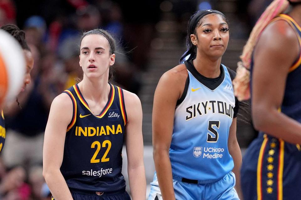 <p>Emilee Chinn/Getty </p> Caitlin Clark #22 of the Indiana Fever and Angel Reese #5 of the Chicago Sky look on during a game at Gainbridge Fieldhouse on June 16, 2024 in Indianapolis, Indiana.