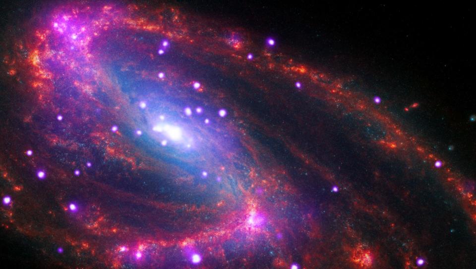 colorful wisps of gas in deep space in front of bright dots of light