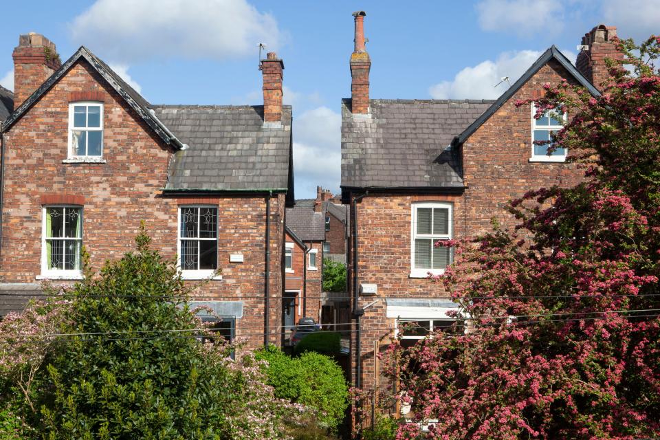 UK house prices Victorian semi-detached houses in the suburb of Chorlton, Manchester, recede into the distance below a blue sky with a few clouds. Anna Watson/Alamy