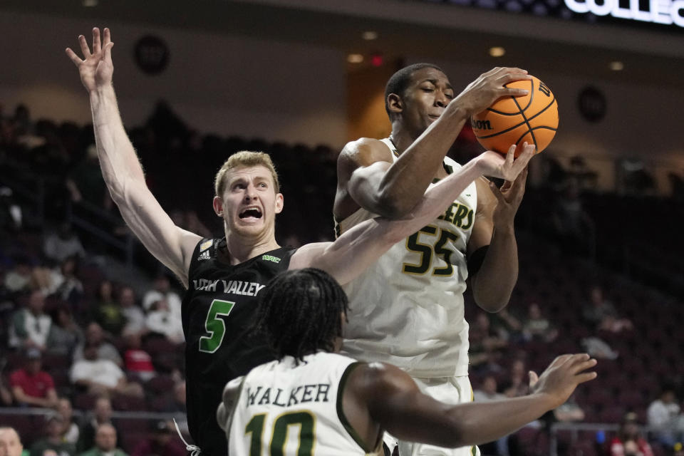 UAB's Trey Jemison (55) grabs a rebound over Utah Valley's Tim Fuller (5) during overtime of an NCAA college basketball game in the semifinals of the NIT, Tuesday, March 28, 2023, in Las Vegas. (AP Photo/John Locher)