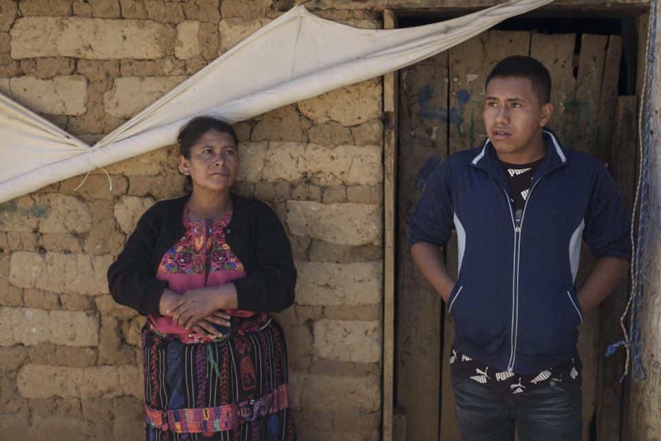 CORRECTS TO CLARIFY THAT SALVADOR TINIGUAR'S WHEREABOUTS ARE UNKNOWN - Dominga Tiniguar and her son Victor Manuel Mateo Tiniguar stand outside their home in Chepol, in the western highlands of Guatemala, Saturday, Dec. 11, 2021. Tiniguar is the mother of Salvador Mateo Tiniguar, who was traveling on the truck that crashed in Mexico that killed 55 migrants. His family does not know what happened to him as they wait for information from Mexican authorities who have released a list of seven seriously injured unidentified people. (AP Photo/Moises Castillo)