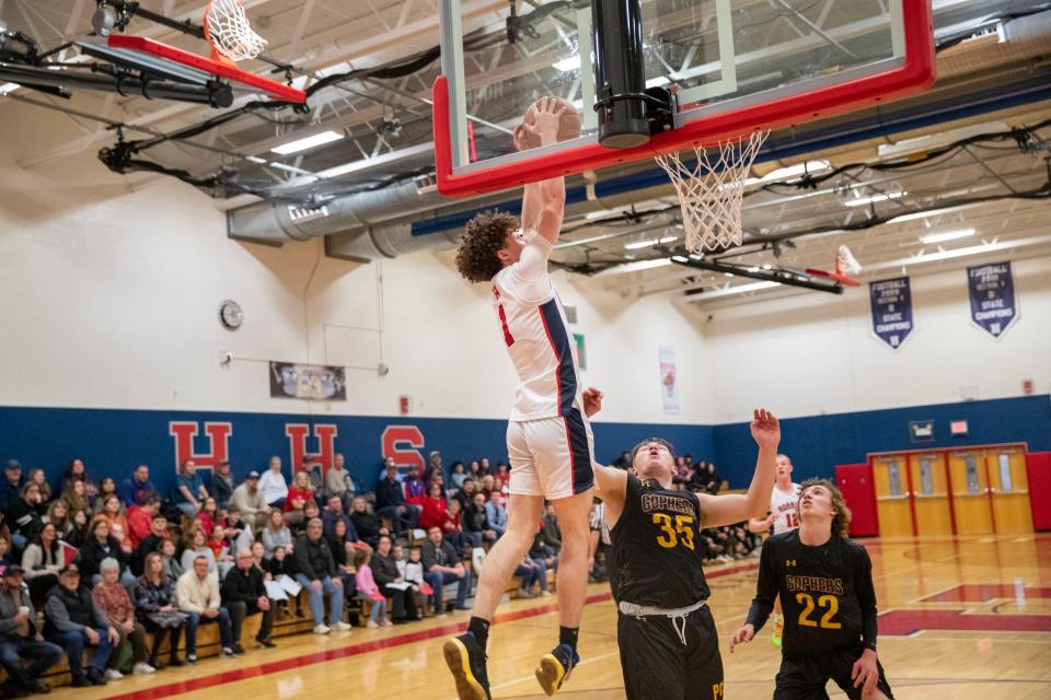 Gennaro Picco soars through the air for an alley-oop from his brother PJ Picco for his record-breaking bucket Tuesday evening in front of a packed gym and a crazed Seneca Street Zoo student section cheering the accomplishment.