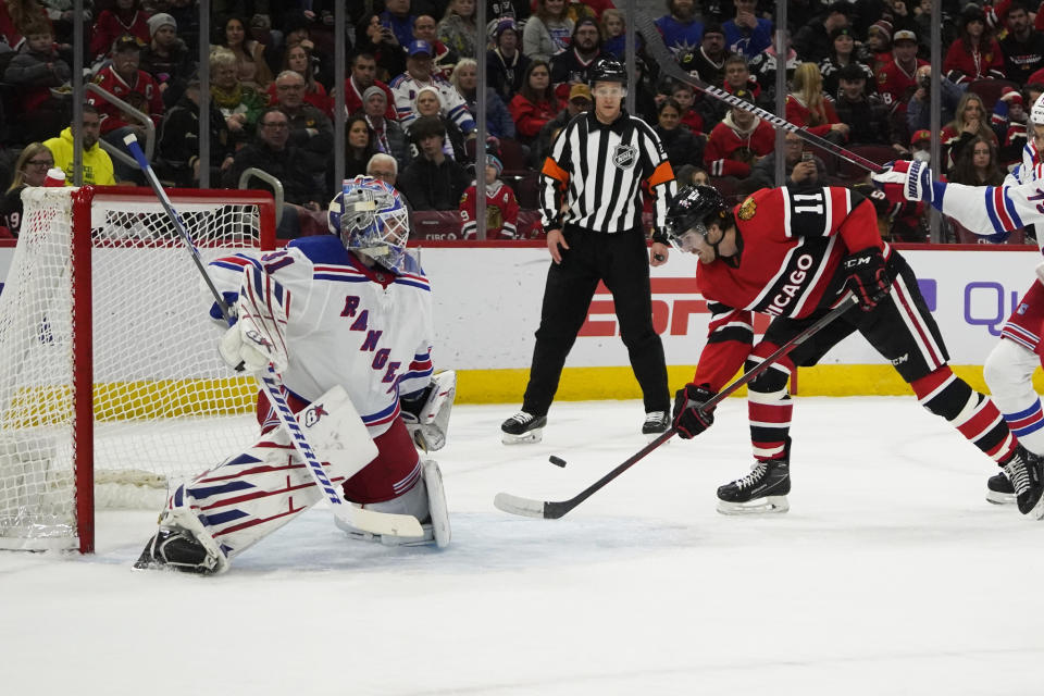 Chicago Blackhawks right wing Taylor Raddysh (11) skates in against New York Rangers goaltender Igor Shesterkin (31) during the first period of an NHL hockey game Sunday, Dec. 18, 2022, in Chicago. (AP Photo/David Banks)