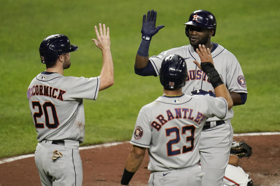 Houston Astros' Yordan Alvarez, top right, is greeted near home plate after he drove in Chas McCormick (20) and Michael Brantley (23) on a three-run home run off Baltimore Orioles starting pitcher Keegan Akin during the third inning of a baseball game, Monday, June 21, 2021, in Baltimore. (AP Photo/Julio Cortez)