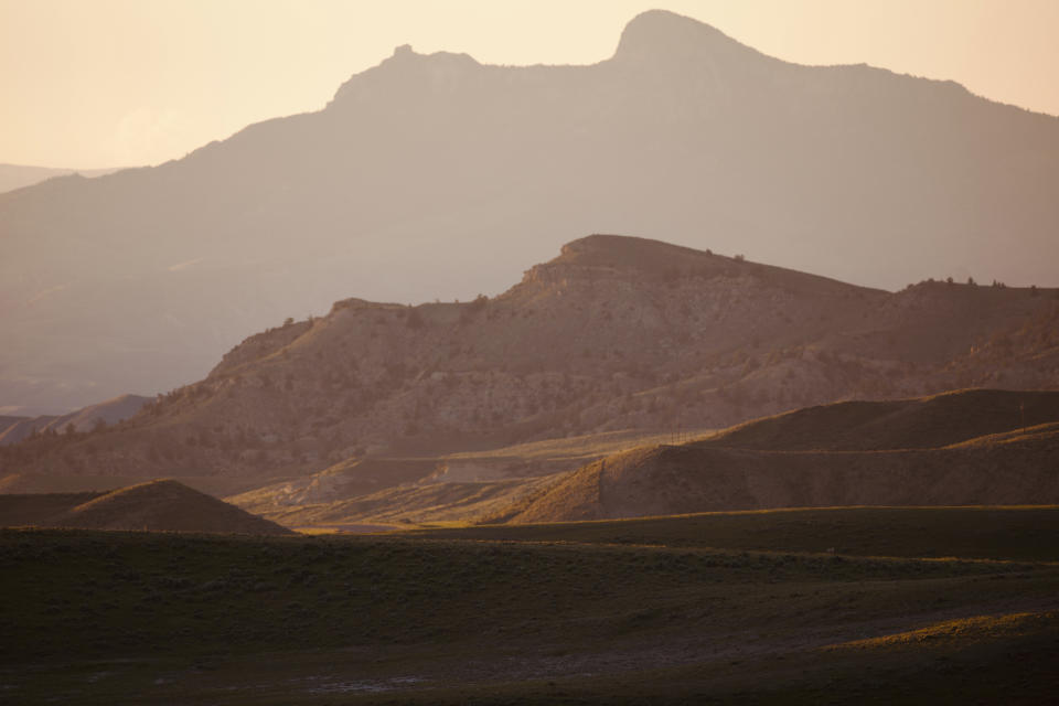 This Wednesday, June 15, 2022 photo shows hills outside Cody, Wyo. The region is ground zero in the conflict between golden eagles and wind farms, which both find homes in areas where there are strong winds. As wind turbines proliferate, scientists say deaths from collisions could drive down golden eagle numbers considered stable at best and likely to drop in some areas. (AP Photo/Emma H. Tobin)