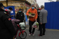 A man leaves with his grocery shopping from a community under lockdown in Beijing, Thursday, Nov. 24, 2022. China is expanding lockdowns, including in a cental city where factory workers clashed this week with police, as its number of COVID-19 cases hit a daily record. (AP Photo/Ng Han Guan)