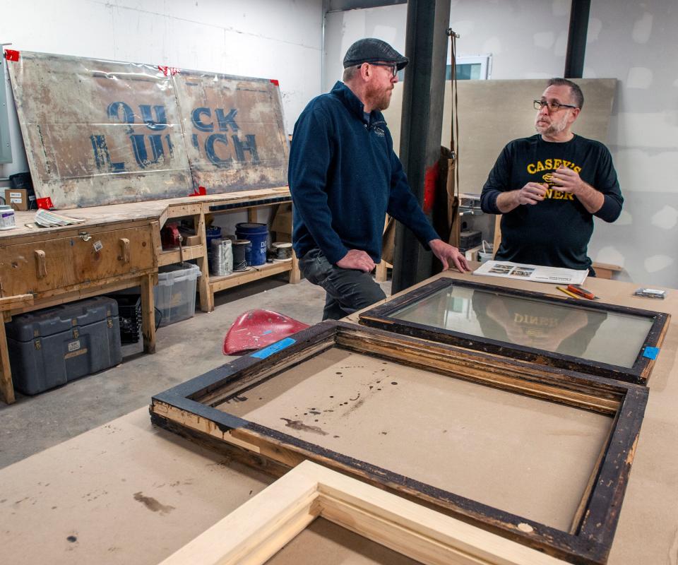 Duane Houghton, left, of Early American Restoration in Framingham, with Casey's Diner owner Pat Casey in Houghton's shop, April 2, 2024. The Natick diner's original painted exterior "Quick Lunch" panels were discovered during repairs after a car crash into the diner. They're believed to be the last original siding from any Worcester Lunch Car Co. cars in the country.