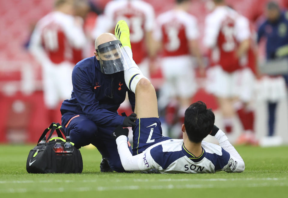 Tottenham's Son Heung-min receives medical attention during the English Premier League soccer match between Arsenal and Tottenham Hotspur at the Emirates stadium in London, England, Sunday, March 14, 2021. (Julian Finney/Pool via AP)