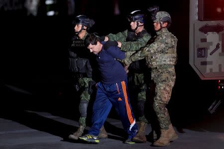 Drug lord Joaquin "El Chapo" Guzman is escorted by soldiers during a presentation in Mexico City, January 8, 2016. REUTERS/Tomas Bravo