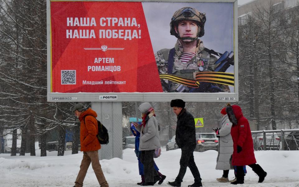 Russians in St Petersburg walk past a billboard proclaiming, 'Our country, our victory!'