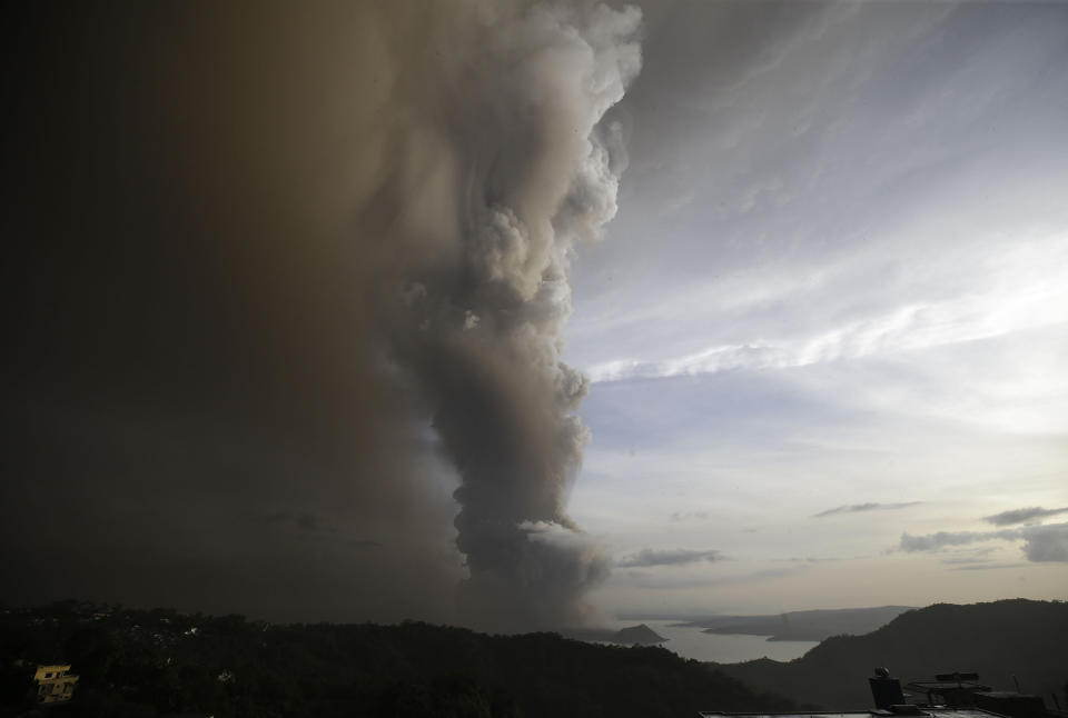 Taal Volcano spews ash as it erupts Sunday Jan. 12, 2020, in Tagaytay, Cavite province, outside Manila, Philippines. A tiny volcano near the Philippine capital that draws many tourists for its picturesque setting in a lake belched steam, ash and rocks in a huge plume Sunday, prompting thousands of residents to flee and officials to temporarily suspend flights. (AP Photo/Aaron Favila)