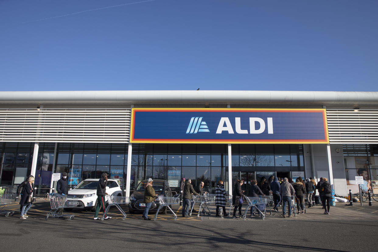 LONDON, ENGLAND - MARCH 23: Shoppers queue outside an Aldi supermarket on March 23, 2020 in London, England. Coronavirus (COVID-19) pandemic has spread to at least 182 countries, claiming over 10,000 lives and infecting hundreds of thousands more. (Photo by Dan Kitwood/Getty Images)