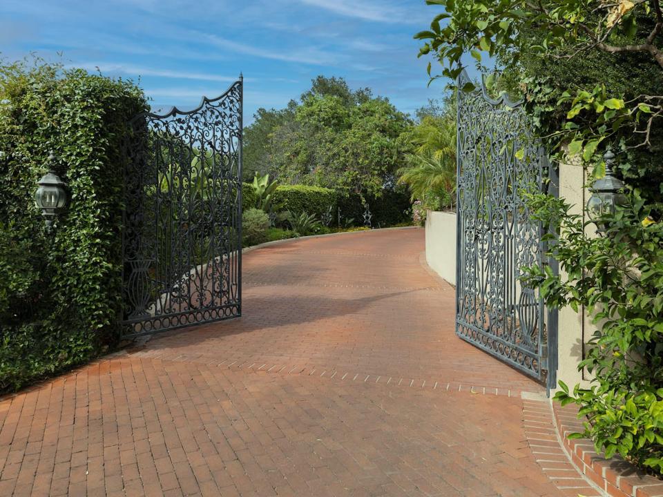 a large metal gate on a brick road