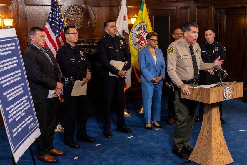 LOS ANGELES, CA - AUGUST 17: LA County Sheriff Robert Luna, flanked by Deputy Chief LAPD Kris Pitcher, left, task force in-charge, Chief LAPD Dominic Choi, Assistant Chief of LAPD Alfred Labrata, L.A. Mayor Karen Bass, LA Police Commissioner Dr. Erroll Southers and Glendale Police Chief Manuel Cid, talks about forming a task force to investigate, apprehend and prosecute suspects who have committed retail thefts smash-and-grabs in recent weeks, at a press conference held at City Hall in Los Angeles, CA. (Irfan Khan / Los Angeles Times)