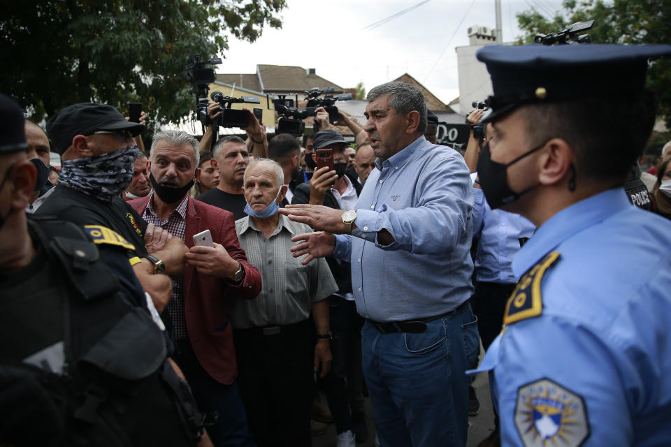 War veterans react with police after Hysni Gucati head of the War Veterans Organization of the Kosovo Liberation Army was arrested, in Pristina, Friday, Sept. 25, 2020. Witnesses say European Union security police have stormed the offices of a war veterans association in Kosovo. The association represents the former ethnic Albanian separatists who fought Serbian troops in a 1998-1999 war for independence. Members of the group said police from the European Union Rule of Law Mission in Kosovo, or EULEX, prevented them from going into the association’s offices in Pristina on Friday. (AP Photo/Visar Kryeziu)