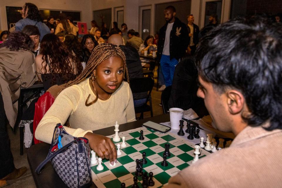 Two people play a game of chess at a table.