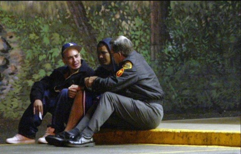 Janet Eaton's son Mario and an unidentified man gathered at the scene of her August 2005 murder and were comforted by a Bremerton Police Department chaplain.