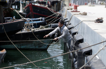 A fisherman anchors a boat at a fish harbour, as Typhoon Mangkhut approaches Shenzhen, China September 15, 2018. REUTERS/Jason Lee