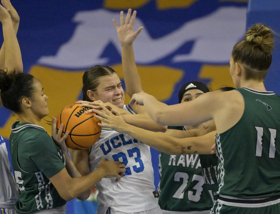 UCLA forward Gabriela Jaquez, center, is fouled as she fights for a rebound against Hawaii guard Olivia Davies, left, guard MeiLani McBee (23) and center Vivienne Berrett, right, in the second half of an NCAA college basketball game Thursday, Dec. 21, 2023, in Los Angeles. (AP Photo/Jayne Kamin-Oncea)