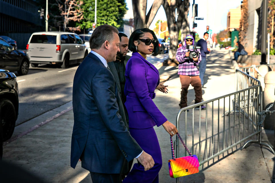 Megan Thee Stallion and two men in suits walks through barricades to enter court (Jason Armond / Los Angeles Times via Getty Images file)