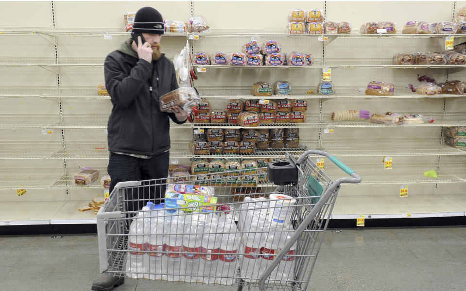 Anchorage resident C.J. Johnson stocks up on water and bread at a local grocery, after the morning's 7.0-magnitude earthquake which caused extensive damage to the local area in Anchorage, Alaska, Friday, Nov. 30, 2018. The earthquake that shook Anchorage and damaged roadways also knocked many traffic lights out of service and has snarled traffic. (AP Photo/Michael Dinneen)