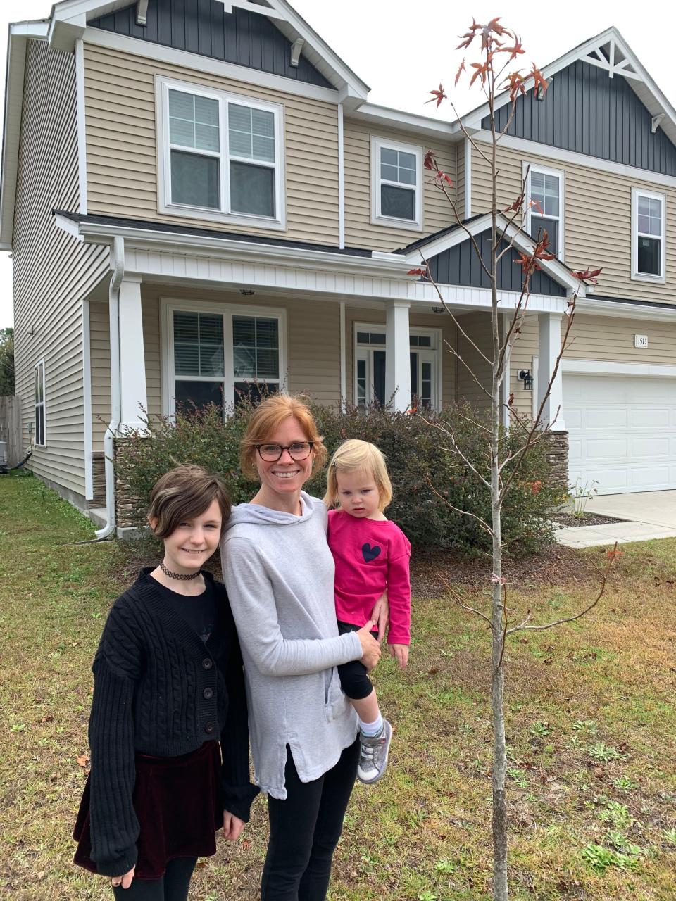 A family enjoys the remarkable growth of their Sweetgum tree from the 2019 Winter Treefest.