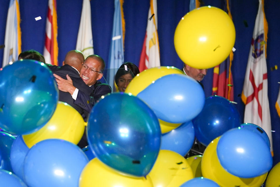 Anthony Brown (facing camera), Democratic nominee for Maryland attorney general, hugs Democrat Wes Moore, left, after Moore was declared the winner of the Maryland gubernatorial race, Tuesday, Nov. 8, 2022, in Baltimore. (AP Photo/Julio Cortez)