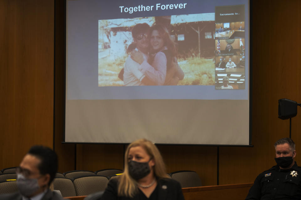 A photo of Brian Maggiore and Katie Maggiore is projected on the screen as Katie's brother Ken Smith makes a statement in front of Joseph James DeAngelo during the third day of victim impact statements at the Gordon D. Schaber Sacramento County Courthouse Thursday, Aug. 20, 2020, in Sacramento, Calif. DeAngelo was known as the East Area Rapist by Feb. 2, 1978, when he fatally shot Katie Maggiore, 20, and Brian Maggiore, 21, as they walked their dog around their Rancho Cordova neighborhood in Sacramento County. (Santiago Mejia/San Francisco Chronicle via AP, Pool)