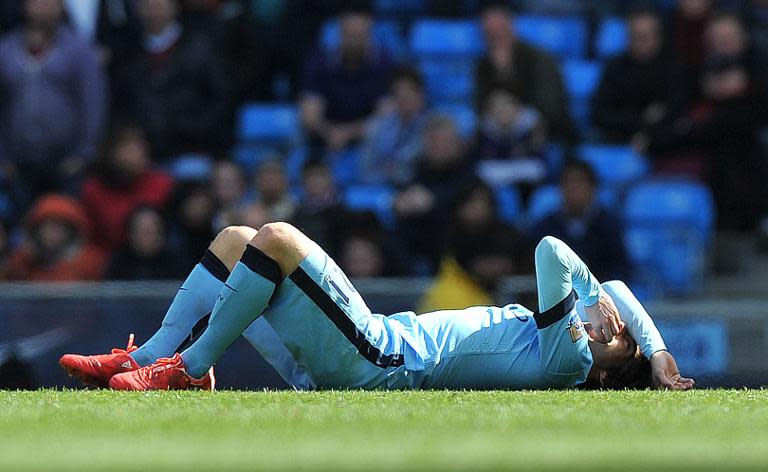 Manchester City's Spanish midfielder David Silva lies injured after taking a knock in the face in a challenge with West Ham United's midfielder Cheikhou Kouyate on April 19, 2015