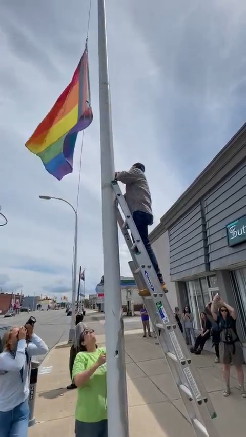 Ross Gordon, chair of Hamtramck human relations commission, raises LGBTQ+ pride flag with help of ex-Mayor Pro Tem Catrina Stackpoole on July 9, 2023.