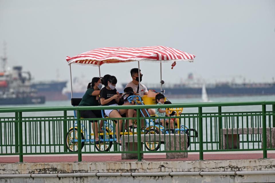 A family ride a multi-cycle along the jetty at Eastcoast park beach in Singapore on April 1, 2021. (Photo by ROSLAN RAHMAN / AFP) (Photo by ROSLAN RAHMAN/AFP via Getty Images)