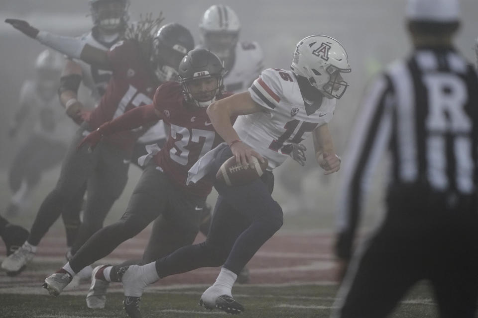 Arizona quarterback Will Plummer (15) is pursued by Washington State linebacker Justus Rogers (37) during the second half of an NCAA college football game, Friday, Nov. 19, 2021, in Pullman, Wash. Washington State won 44-18. (AP Photo/Ted S. Warren)