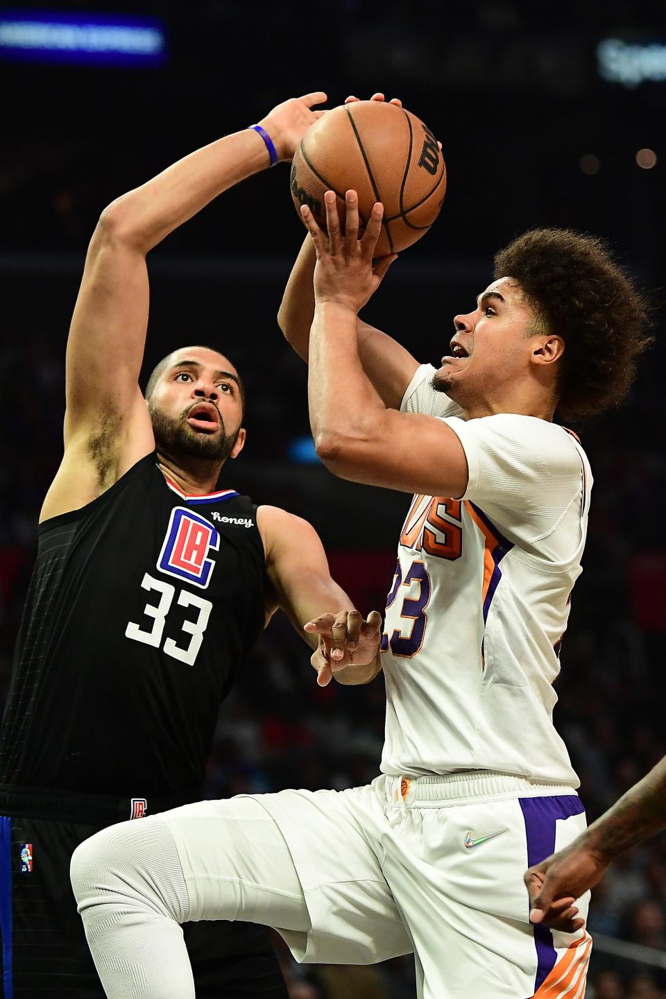 Apr 6, 2022; Los Angeles, California, USA; Phoenix Suns forward Cameron Johnson (23) moves to the basket against Los Angeles Clippers forward Nicolas Batum (33)  during the first half at Crypto.com Arena.