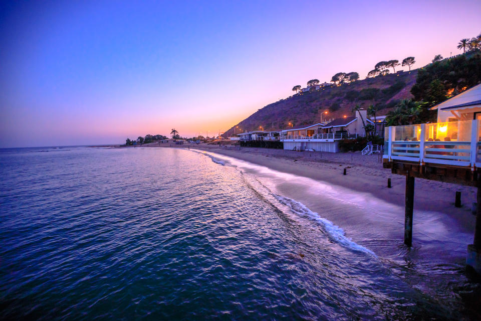 Scenic coastal landscape with Santa Monica Mountains and Surfrider Beach at dusk iluminated by night. Malibu, California, United States. Californian West Coast travel. Copy space.