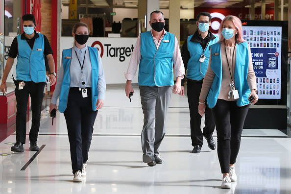 Members of the Broadway Shopping Centre team are seen wearing face masks in Sydney, Australia. 